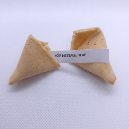 Two mini fortune cookies on a textured white background, connected by a white paper band that reads 'YOUR MESSAGE HERE'.